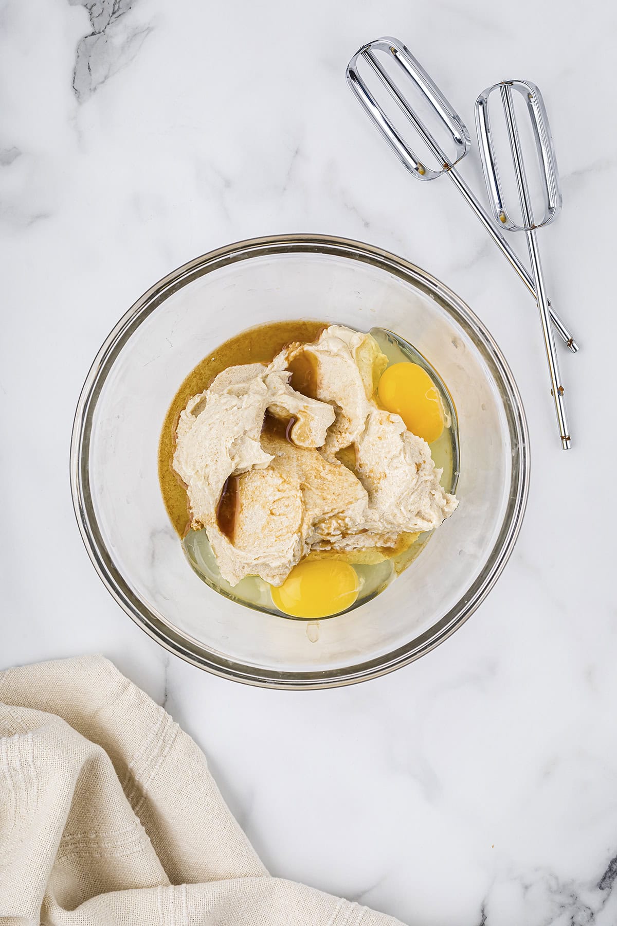 Creamed butter and sugar with eggs and vanilla in mixing bowl.