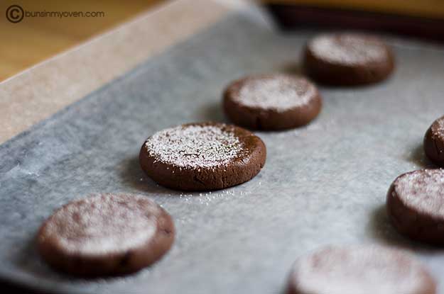 Chocolate cookies topped with sugar on a baking sheet 