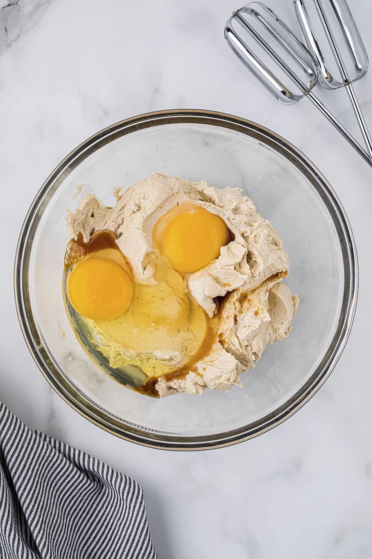 Butter and sugar creamed in a bowl with eggs.