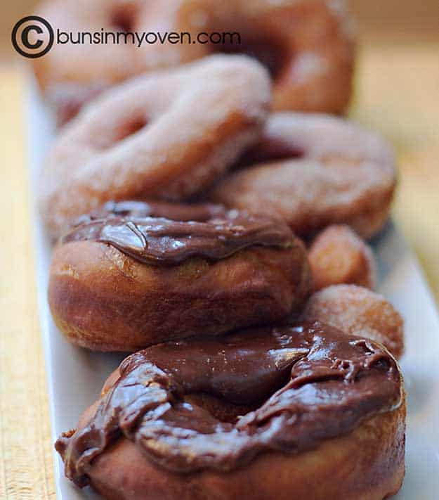 A row of chocolate doughnuts on an appetizer tray
