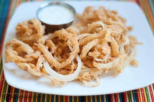 The white plate full of onions strings 