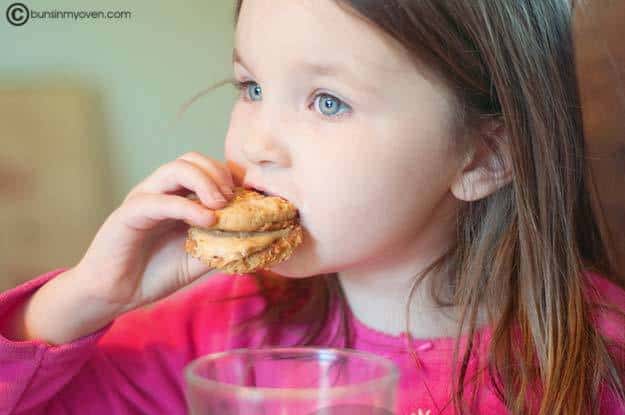 A little girl that is eating a cookie