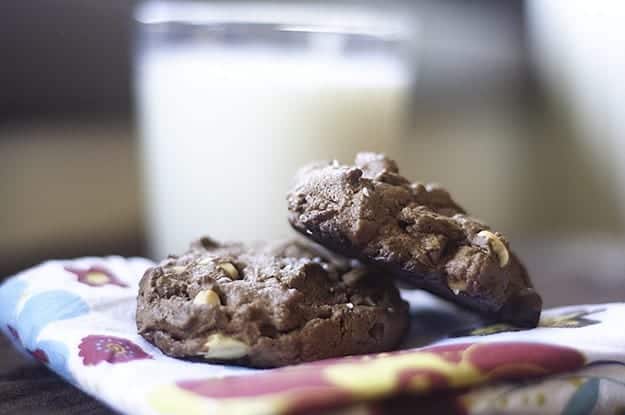 A close up of chocolate peanut butter cookies in front of a glass of milk.