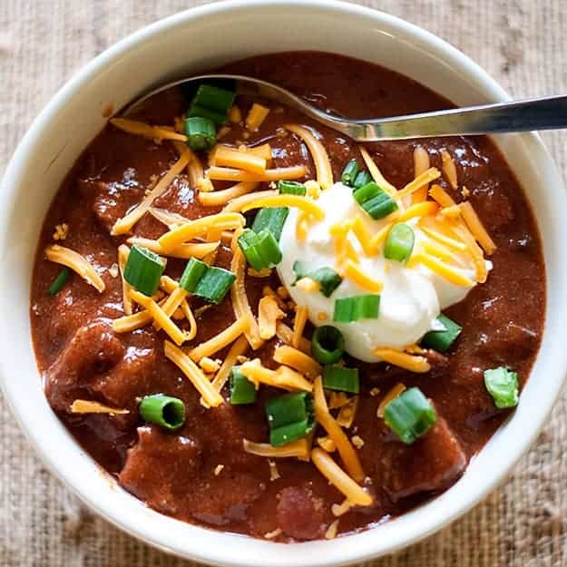 Overhead view of a bowl of chili with a spoon and it 
