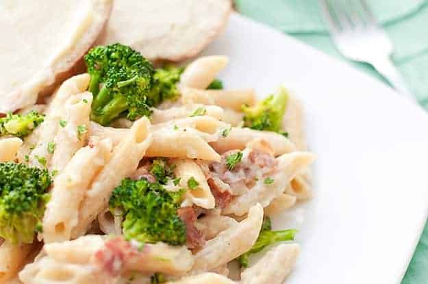bacon penne alfredo on plate with fork