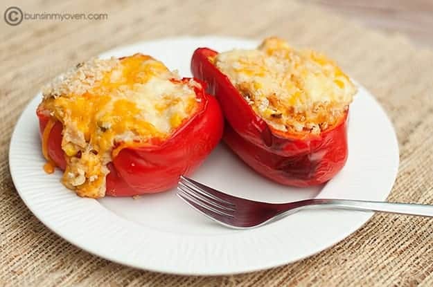 Chicken and cream cheese stuffed peppers on white plate with fork.