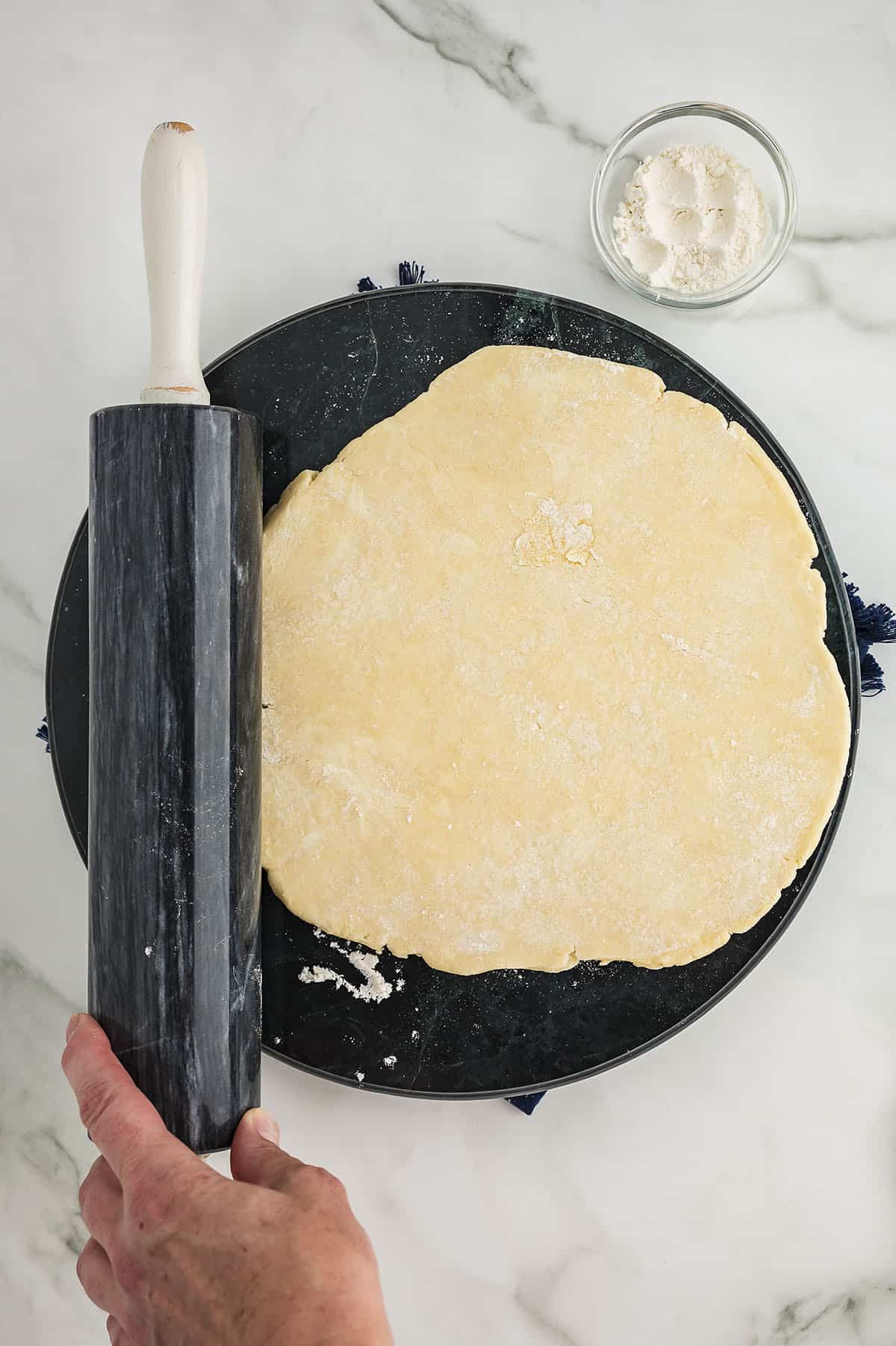 Pie dough being rolled out into a circle.