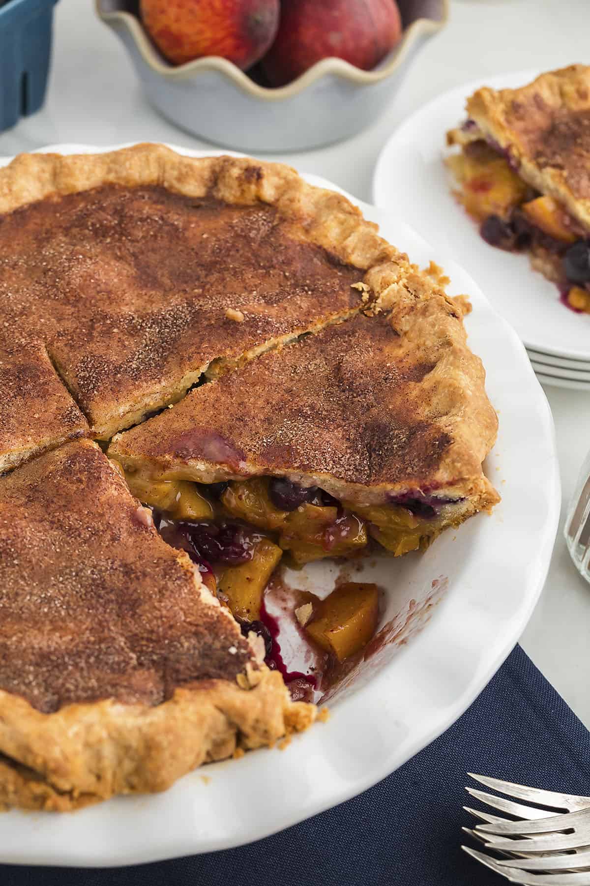 Blueberry peach pie with cinnamon sugar topping on crust.