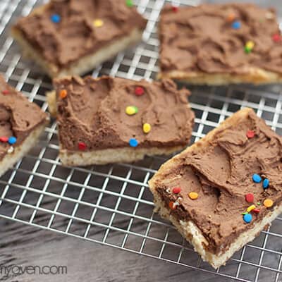 Sugar cookie bars with chocolate icing on a cooling rack