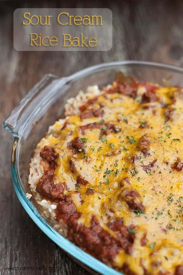 Melted cheese on top of ground beef and rice in a clear glass pan 