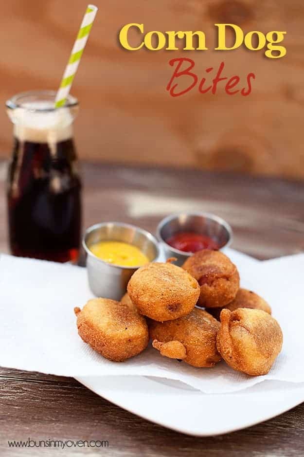 Corn dog bites on a plate with a cup of ketchup and a cup of mustard 