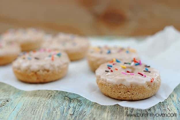 A side view of doughnuts topped with sprinkles on a table