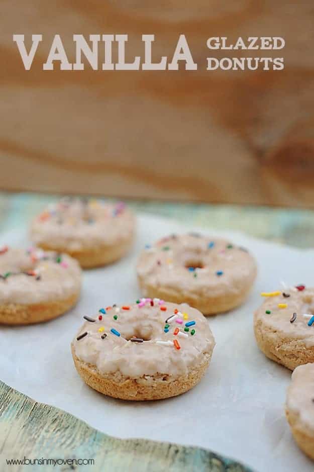 Several vanilla donuts spread out on a table