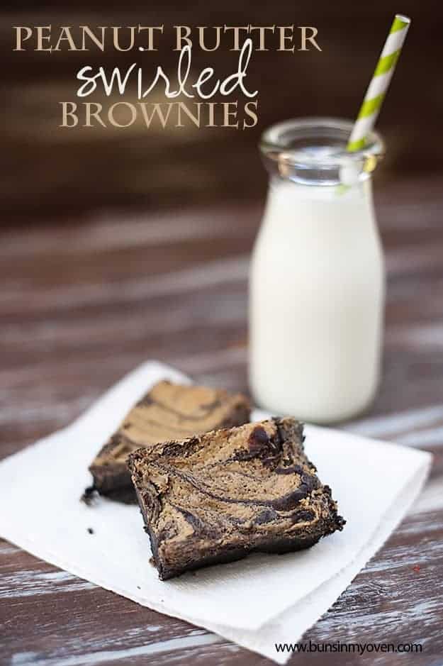A close up of a peanut butter brownie on a napkin in front of a milk jar.