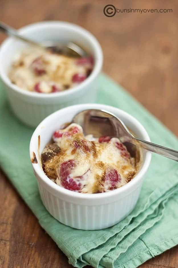 A white cup of raspberry gratin with a spoon in it.