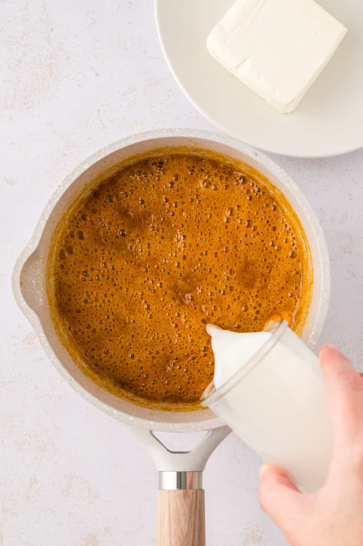 Milk being poured into roux.