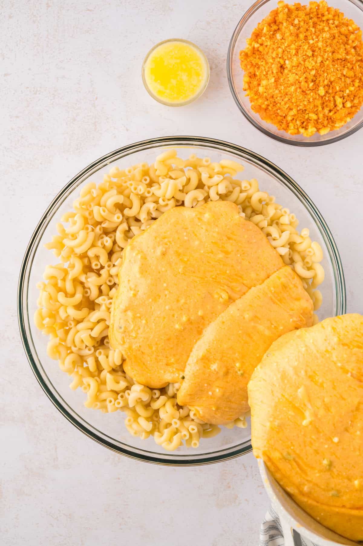 Cheese sauce being poured over macaroni.