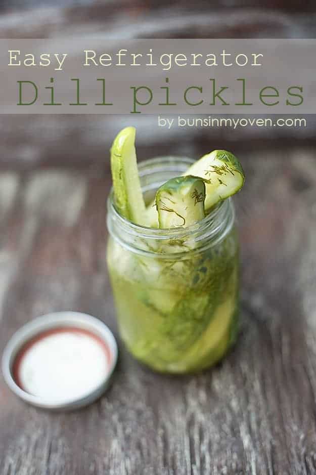 Dill pickle spears in a glass jar with a few spears sticking out.