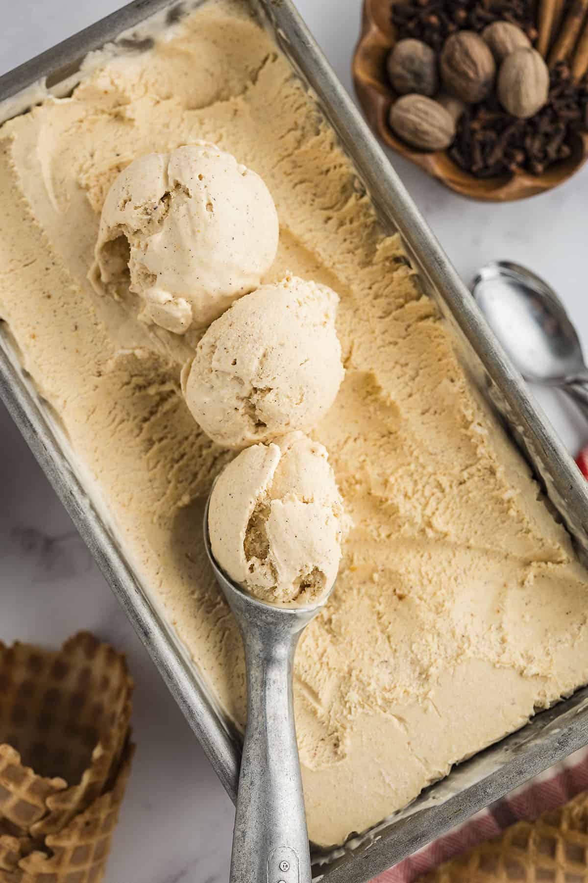 Scoops of pumpkin ice cream in metal tin.