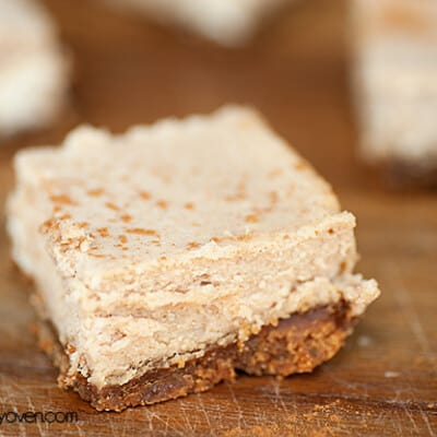 A close up of a cinnamon cheesecake on a wooden cutting board.