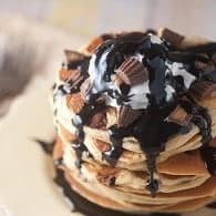 Peanut butter pancakes topped with homemade chocolate syrup and chopped up peanut butter cups for an easy dessert that is ready in 15 minutes!