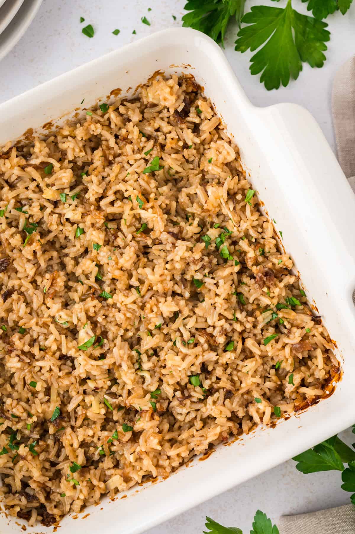 Baked french onion rice in white casserole dish.