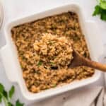 Scoop of french onion rice on wooden spoon.