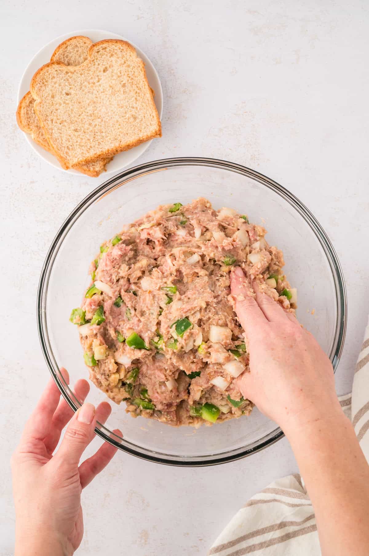 Mixing ingredients for turkey meatloaf in glass bowl.