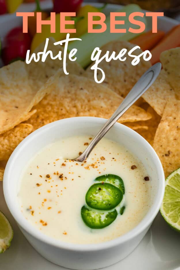 White queso dip in white bowl surrounded by chips.