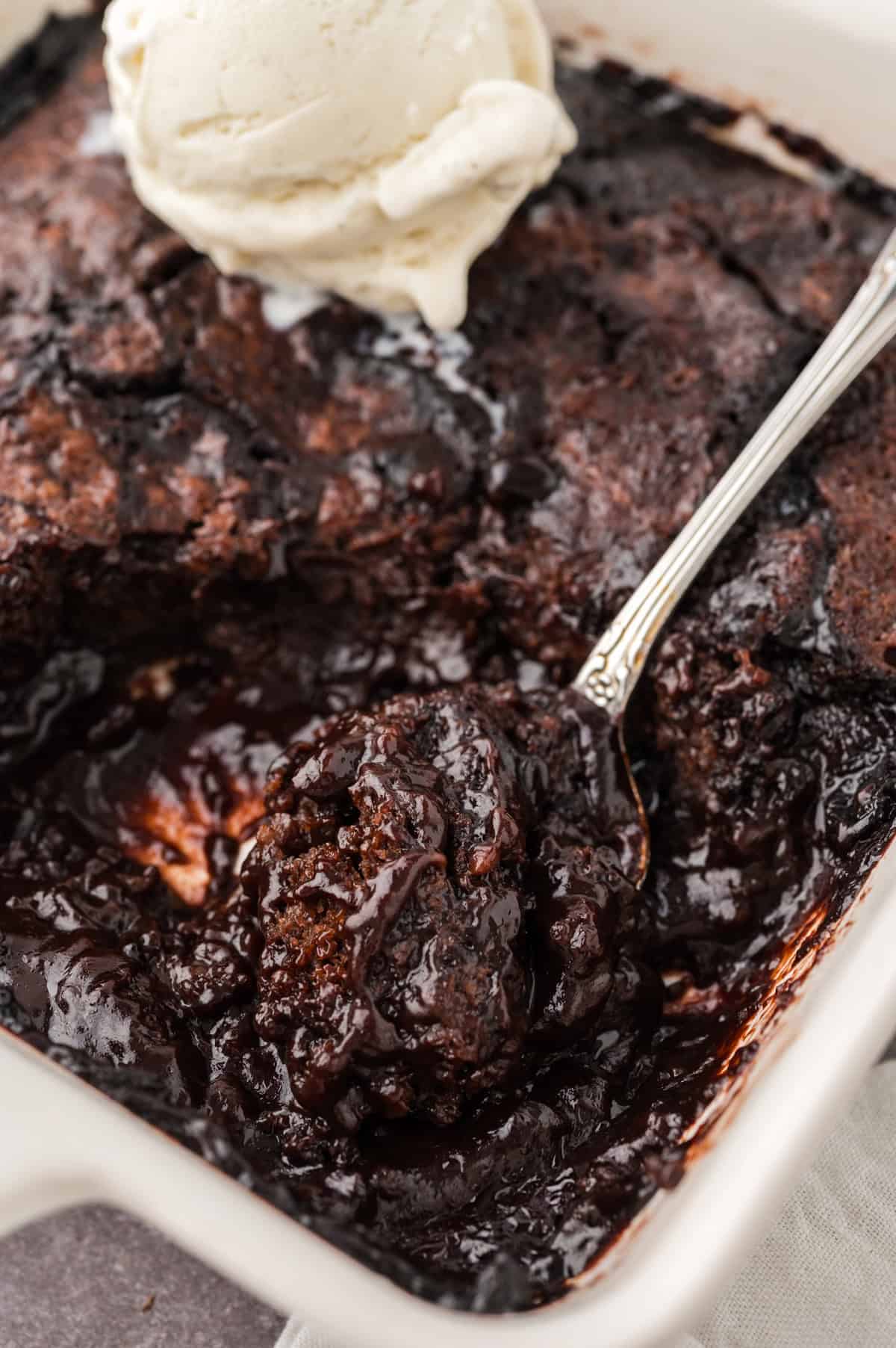 Chocolate cobbler in baking dish with spoon.