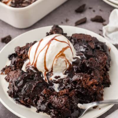 Chocolate cobbler topped with a scoop of vanilla ice cream and chocolate sauce.