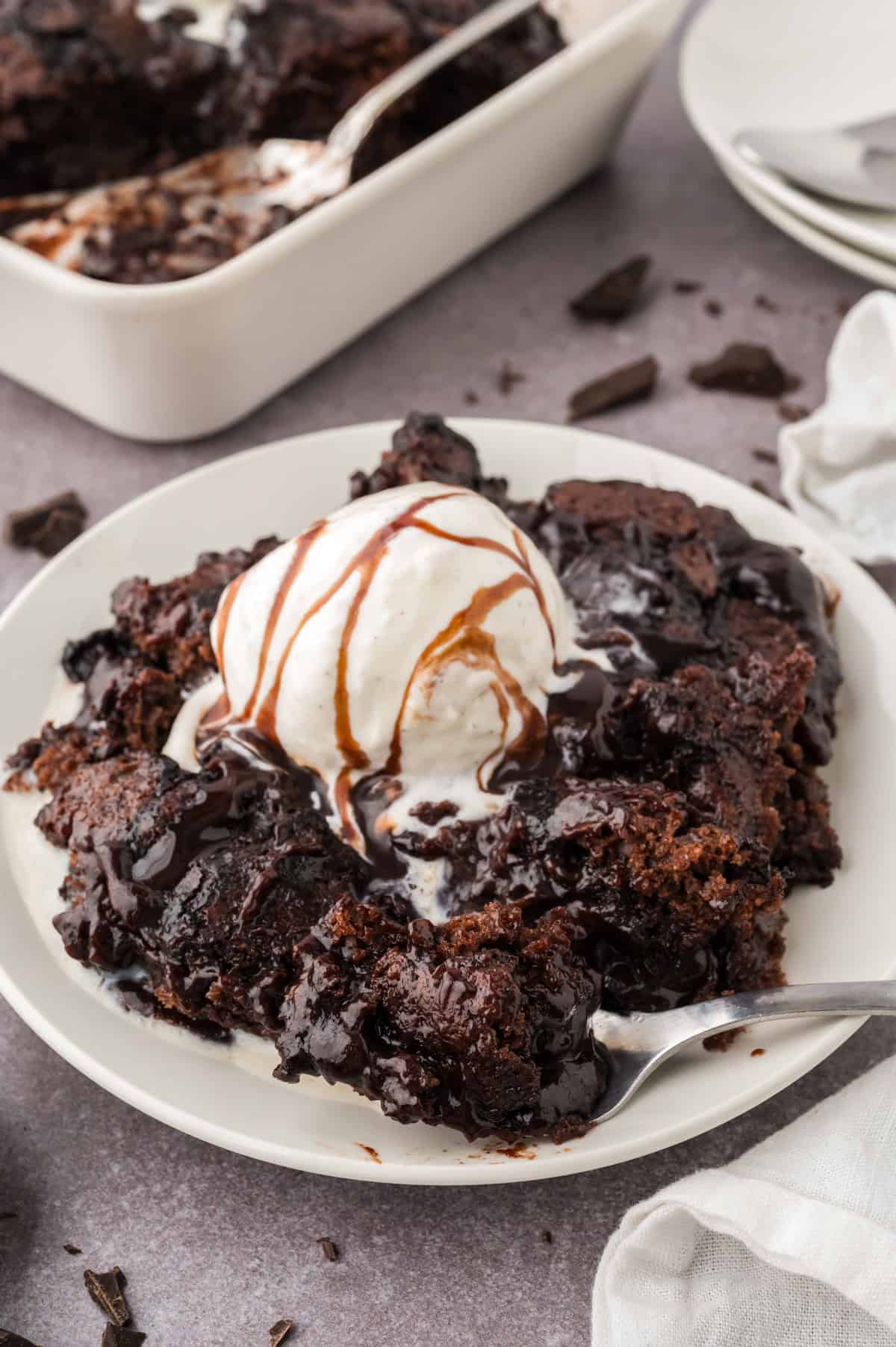 Chocolate cobbler topped with a scoop of vanilla ice cream and chocolate sauce.