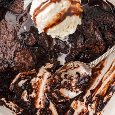 Chocolate cobbler in baking dish with spoon.