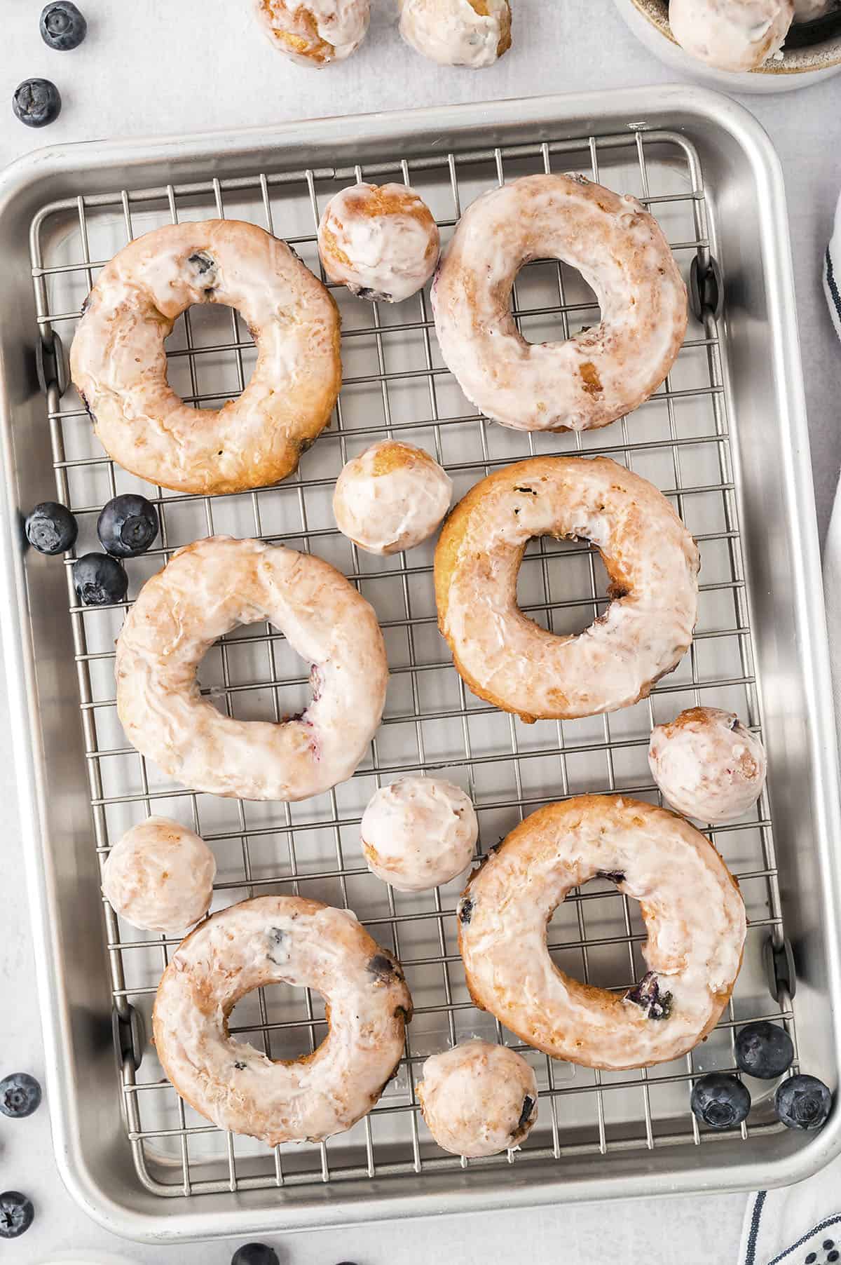 Glazed donuts on wire rack.