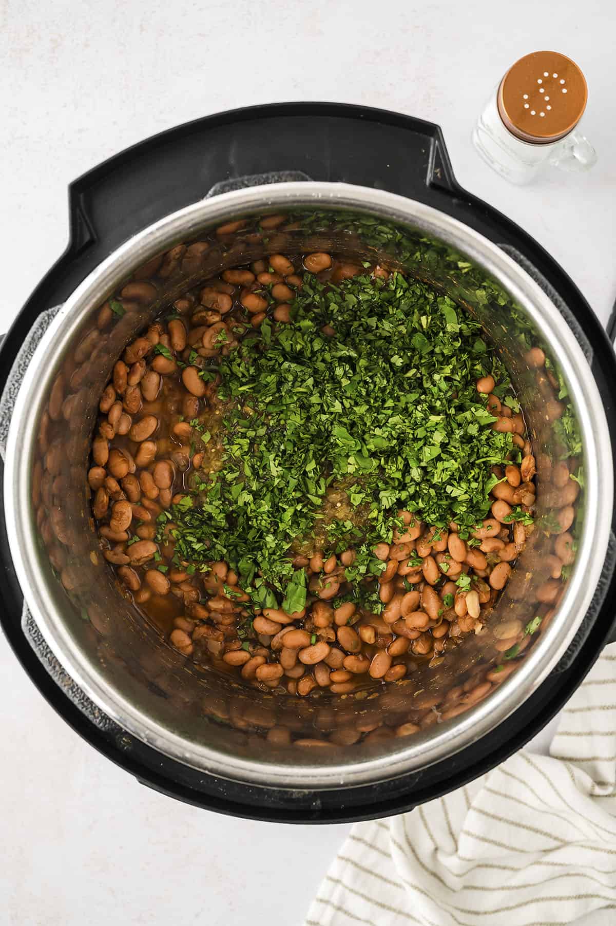 Cilantro added to beans in pressure cooker.