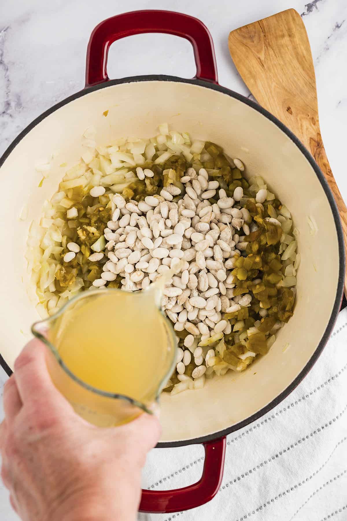 Dried beans and chicken stock added to pot.