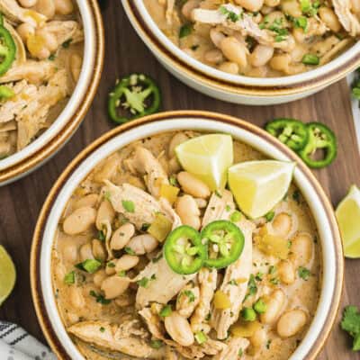 White chicken chili in bowls topped with jalapeno slices.