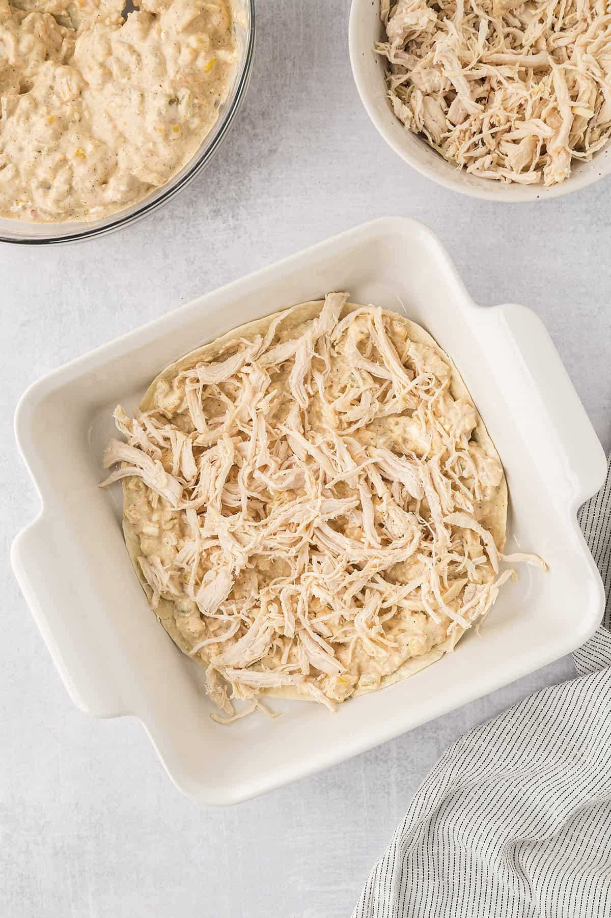 Layered enchiladas in baking dish.