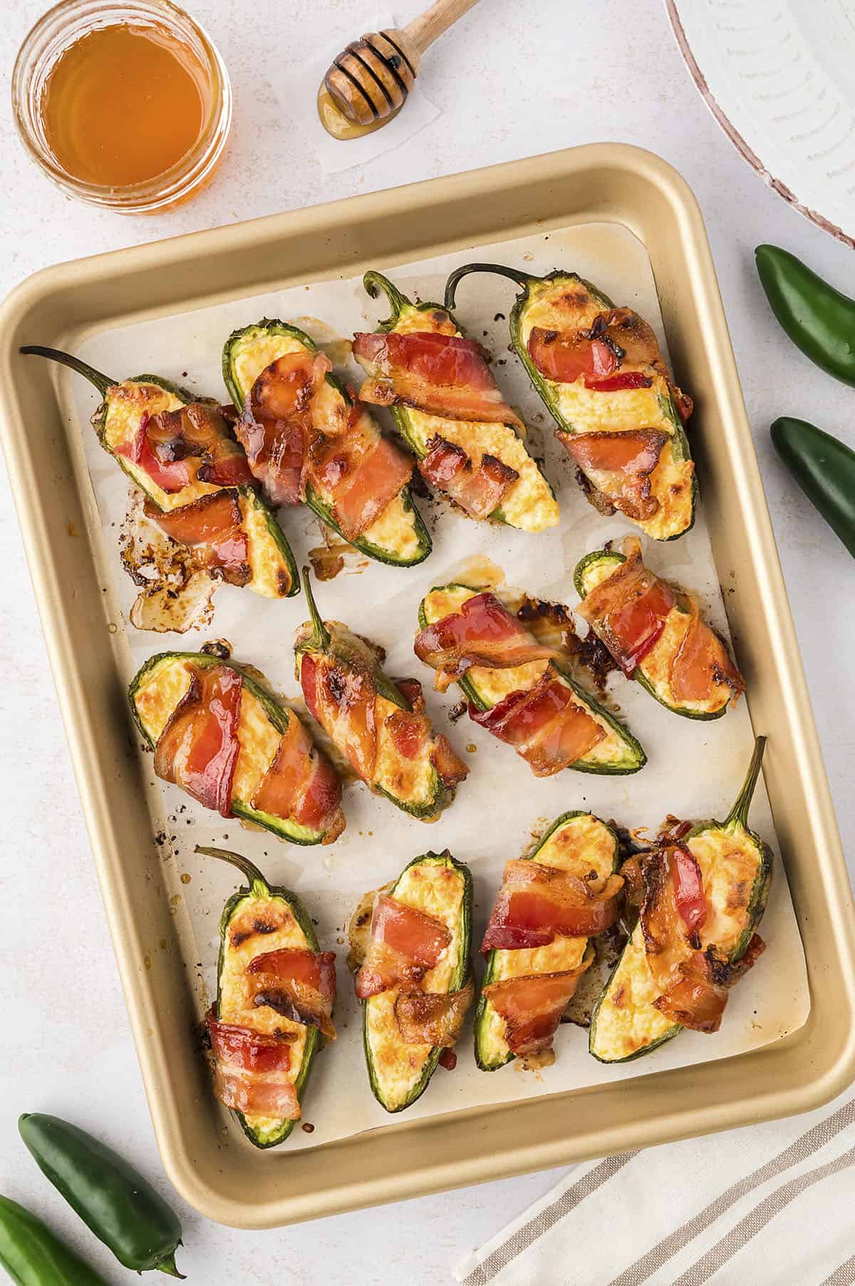 Bacon wrapped jalapeno poppers on sheet pan.