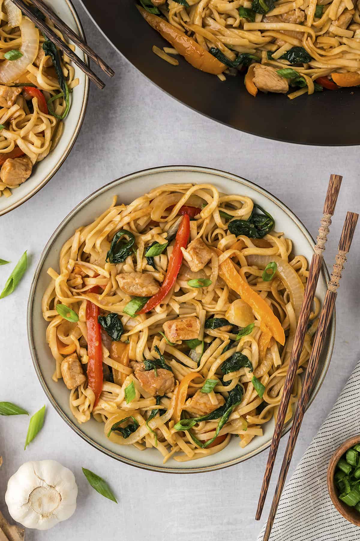 Overhead view of pork lo mein recipe on white plate with chopsticks.