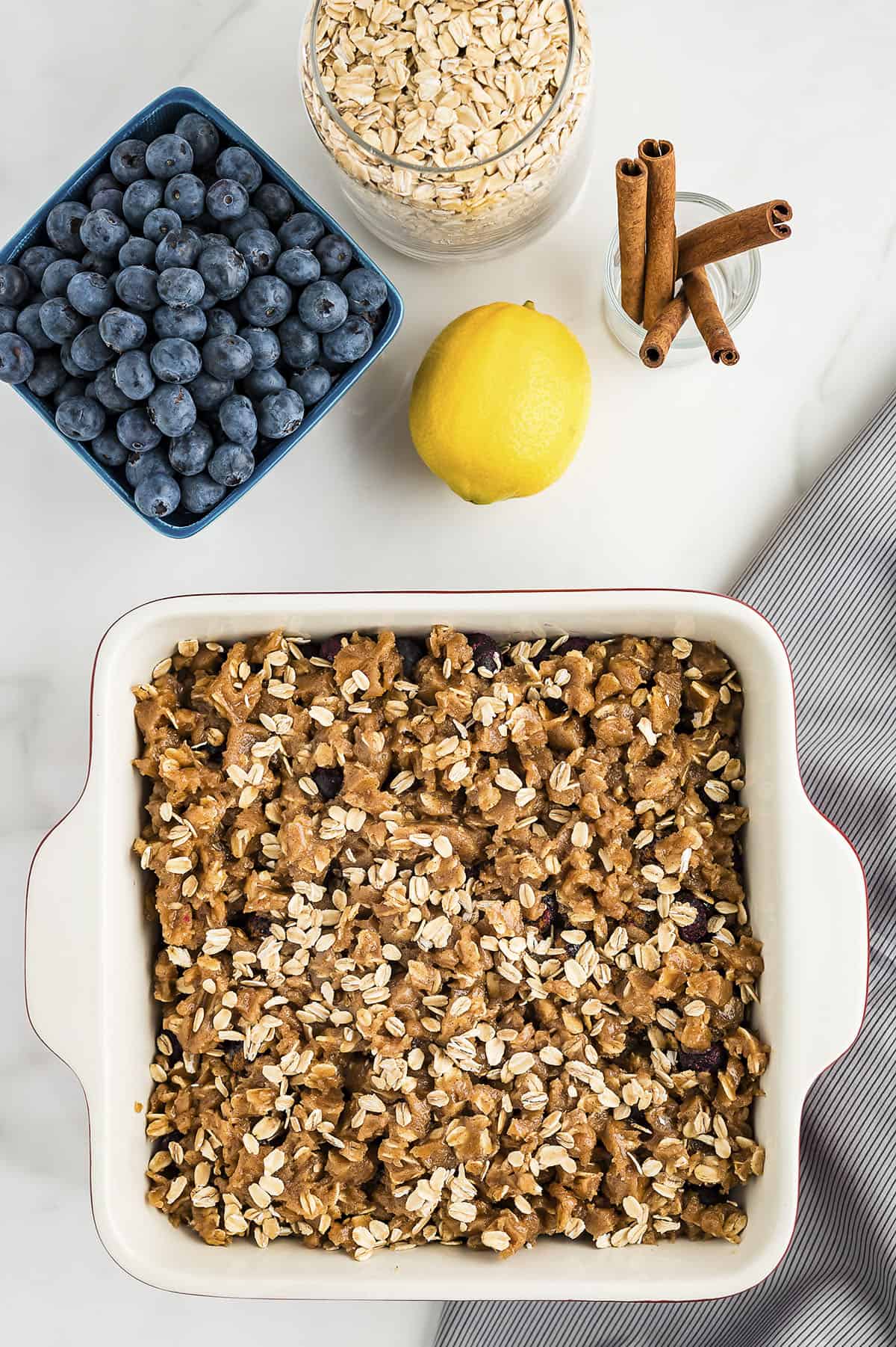 Oat topping over blueberry filling in baking dish.