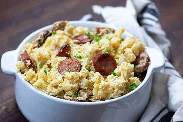 chouriço de salsicha fumada e batatas queijadas em prato branco