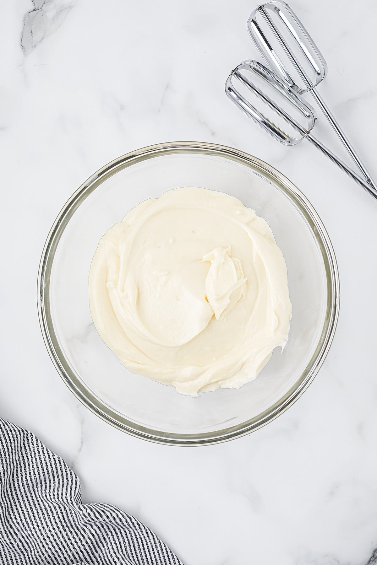 Cream cheese frosting in glass mixing bowl.