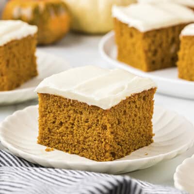 Slices of pumpkin cake on white plates.