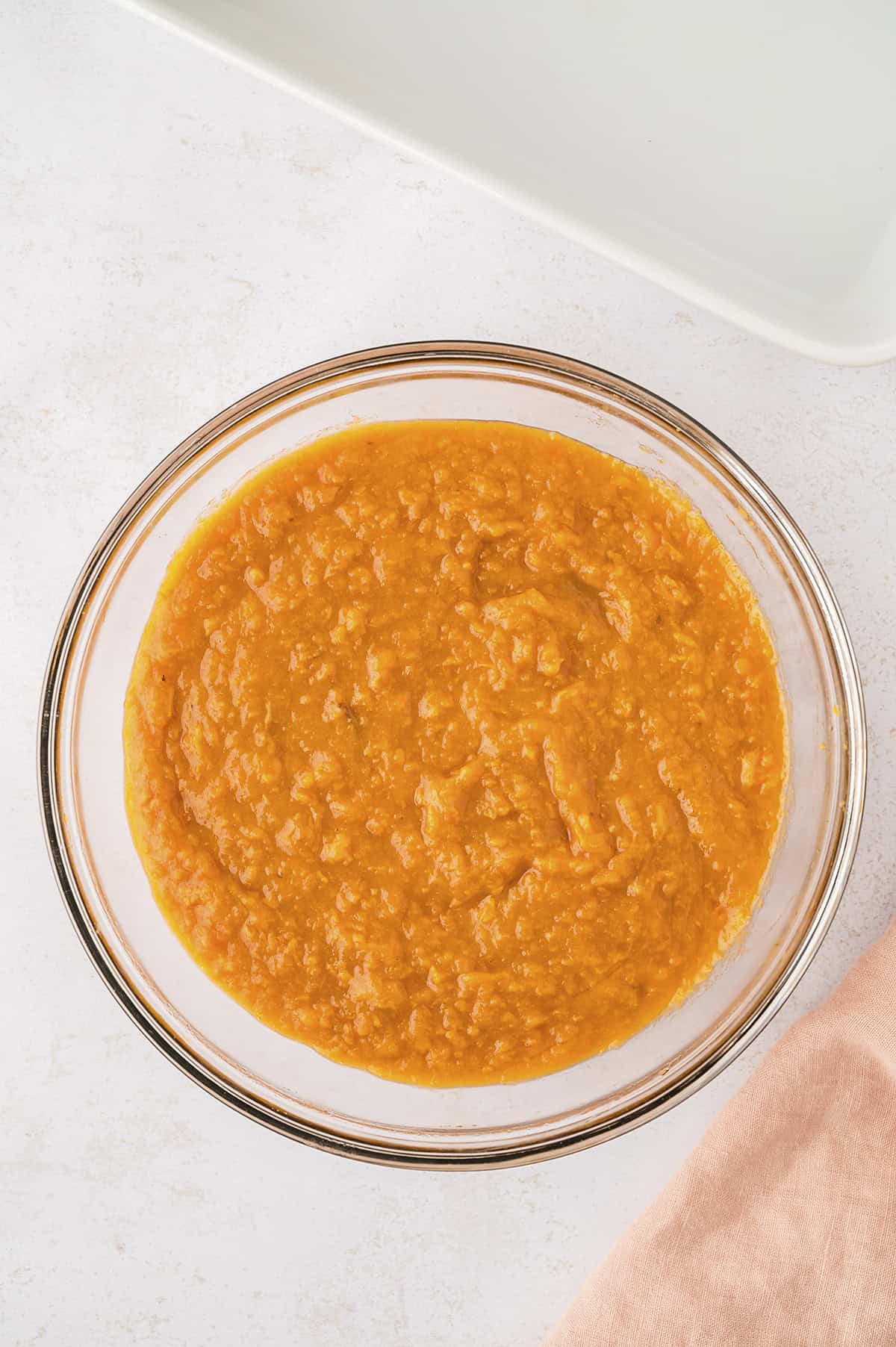 Filling for sweet potato casserole in glass mixing bowl.