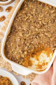 Sweet potato casserole in a white pan on a cloth napkin.