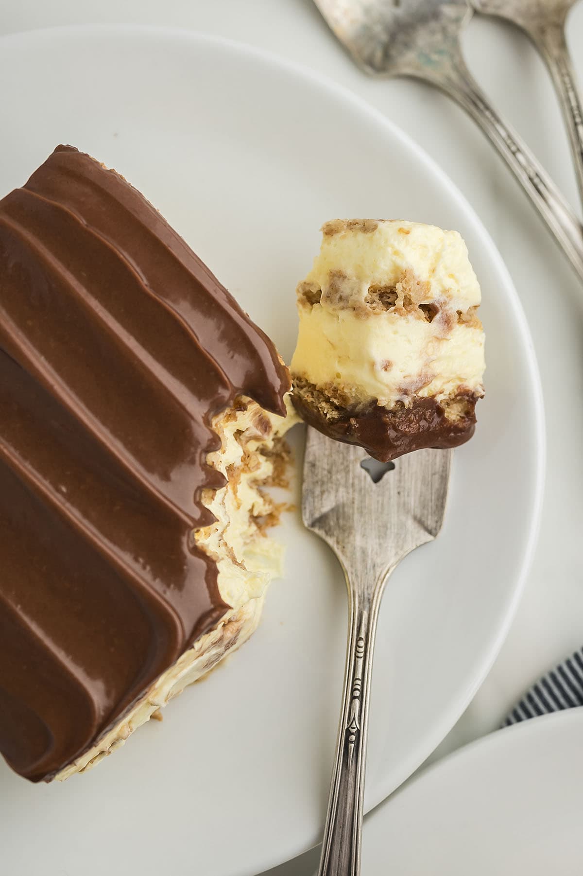 Forkful of eclair cake on white plate.