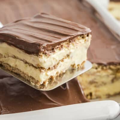 Scoop lifting piece of eclair cake out of pan.