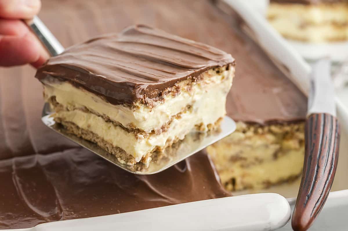 Scoop lifting piece of eclair cake out of pan.