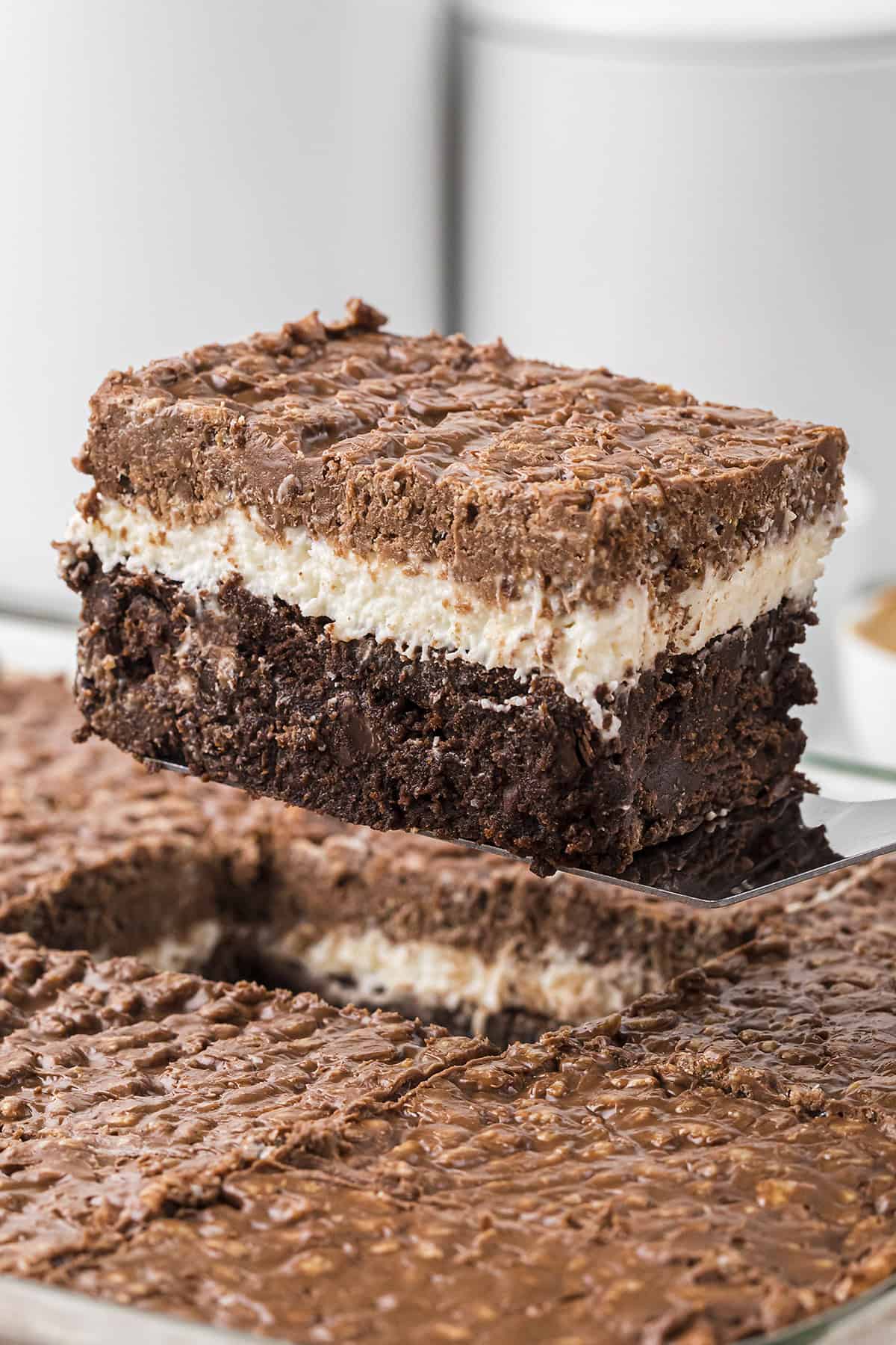 Marshmallow brownies being lifted out of pan on spatula.